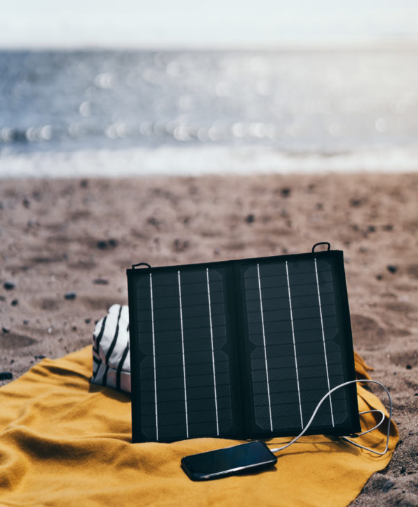 Kodak SP16 kannettava aurinkopaneeli uimarannalla kännykän akkua lataamassa